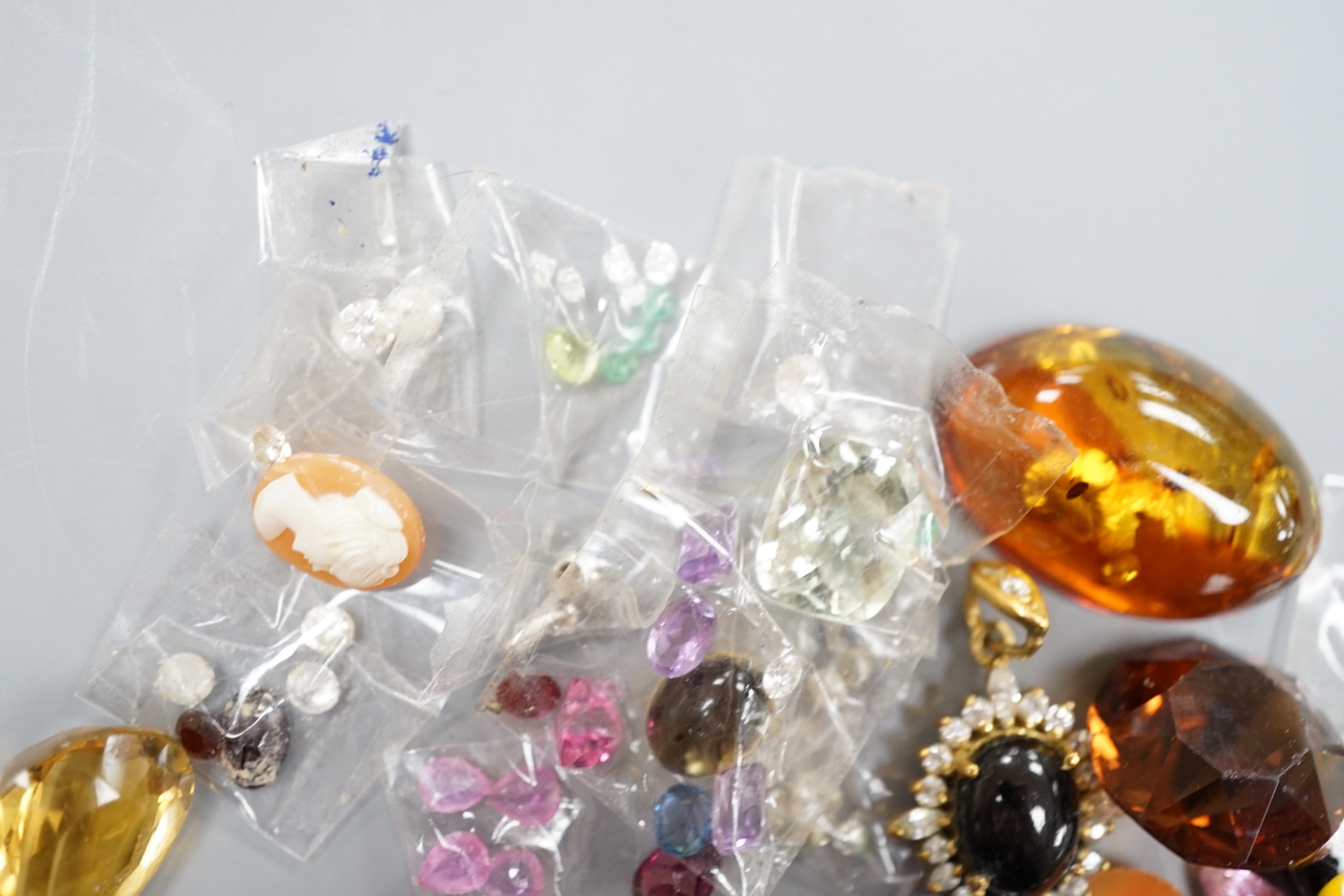 A quantity of assorted unmounted cut gemstones including small diamonds and other minor jewellery.